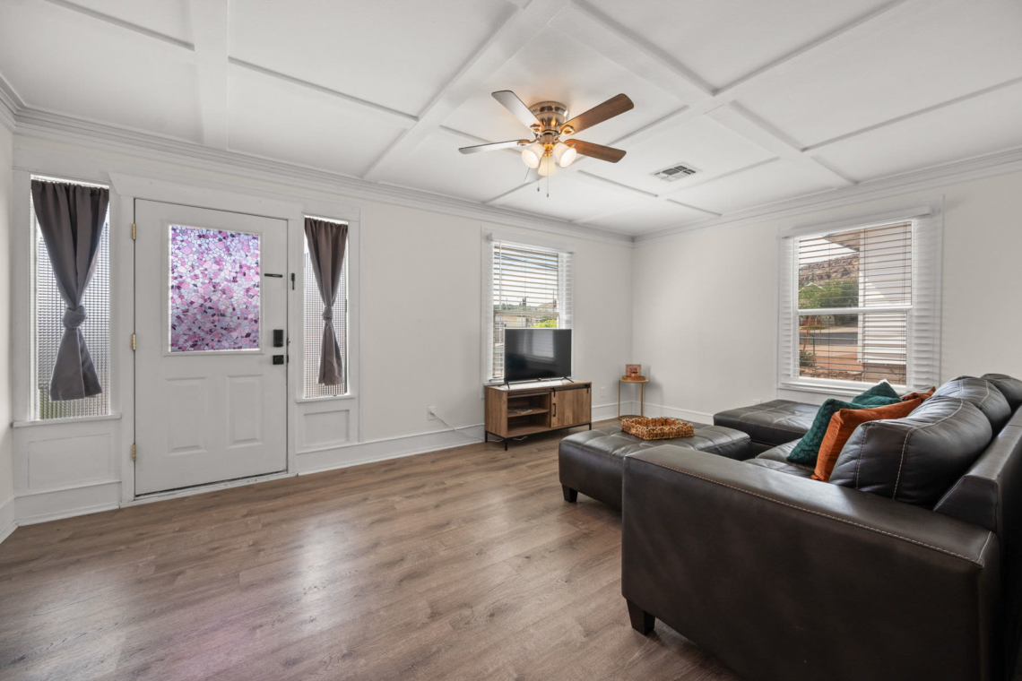 Living room with the front door, sectional and TV