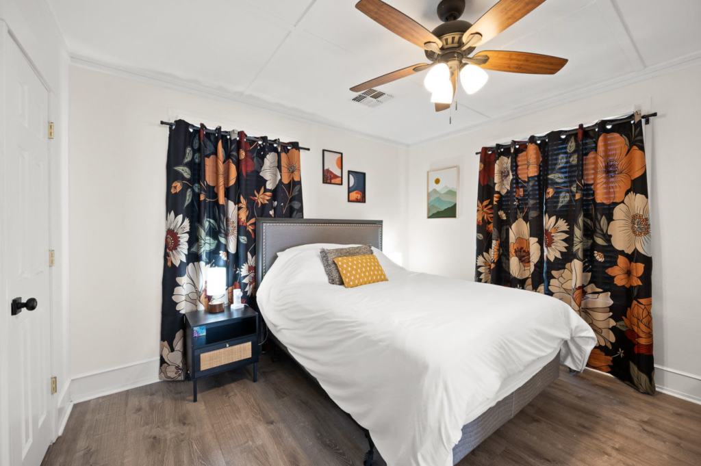 Bedroom with a queen bed and floral curtains