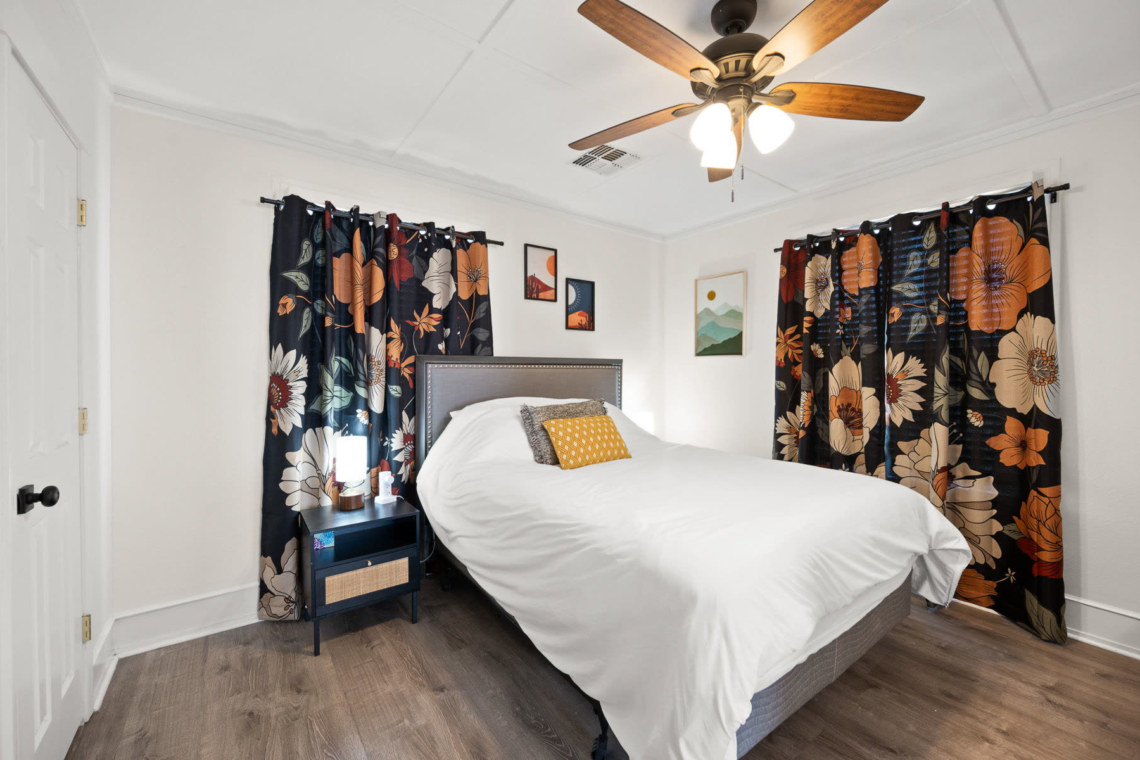 Bedroom with a queen bed and floral curtains