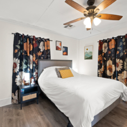 Bedroom with a queen bed and floral curtains